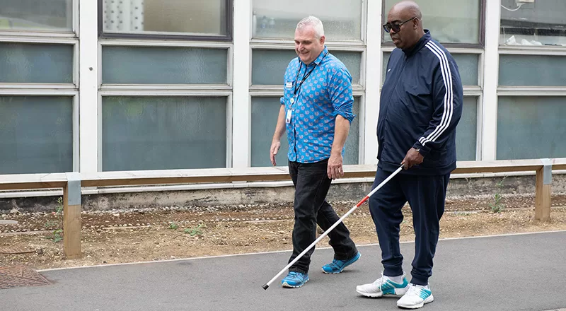 Man teaching another man to use a white cane at Luton Hospital
