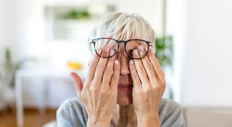 VI Lives. Lady with hands over eyes and glasses over them